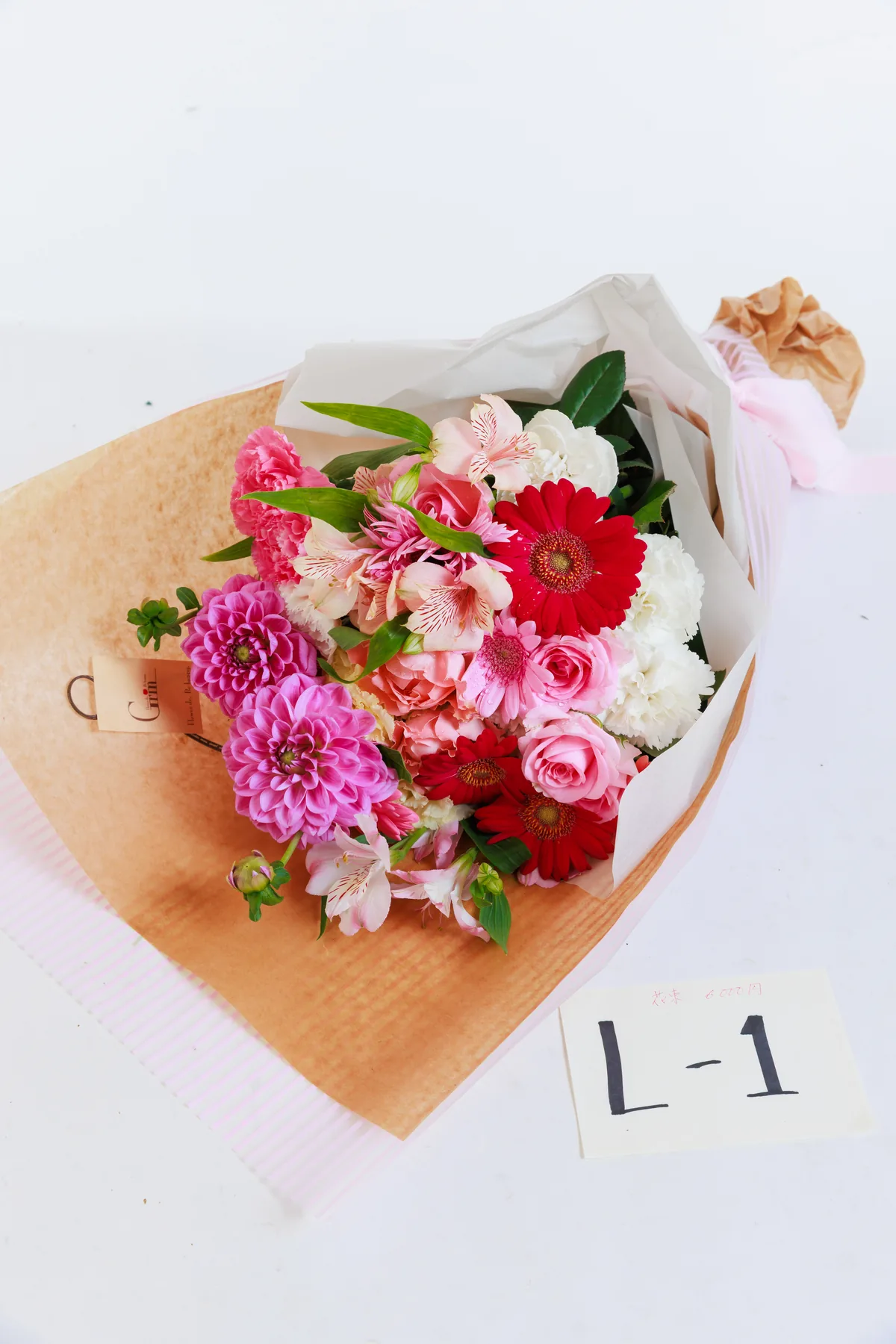 赤やピンクの花をまとめた贈答用の花束